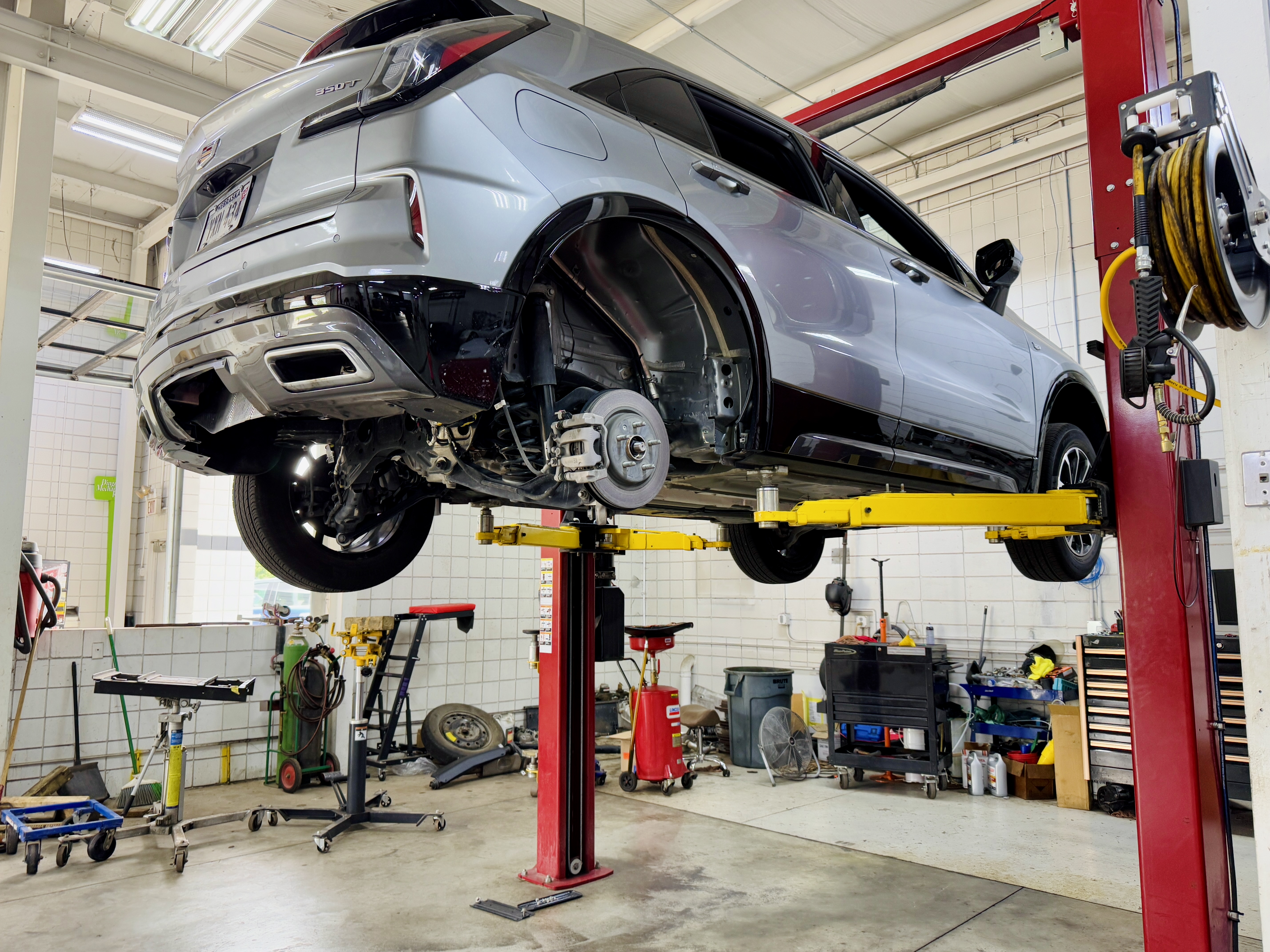 Vehicle raised on a lift inside Dingman’s Mechanical Repair shop