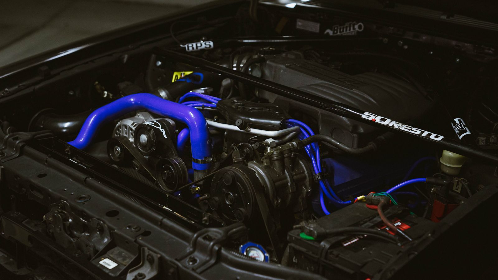 Close-up of an engine bay with blue hoses and mechanical components